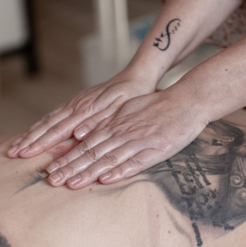 Nærbillede af hænder under fysiurgisk massage på ryg hos Klinik MasAku i Odense